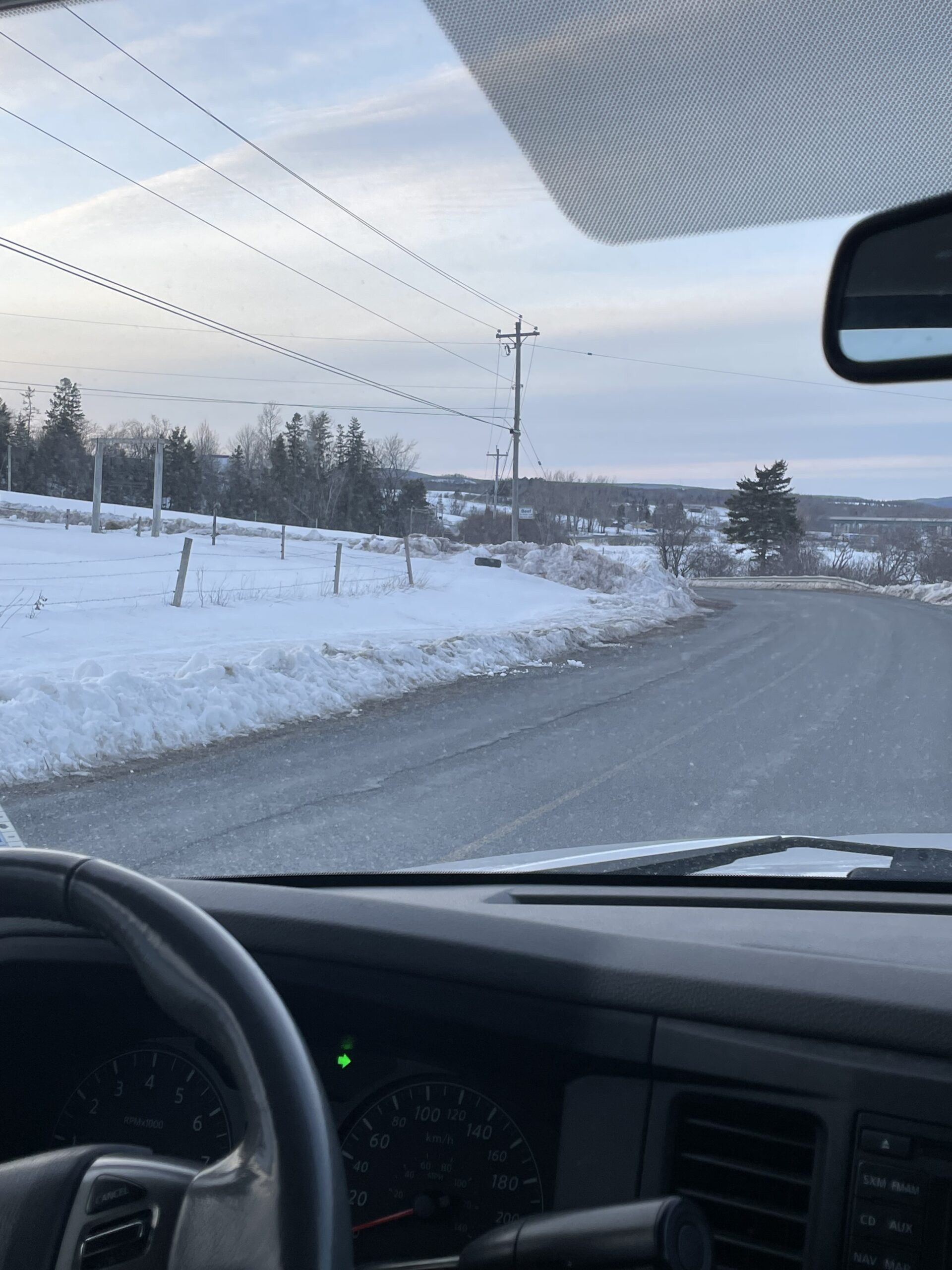 Photo taken of the runaway tire from inside a vehicle parked on the side of a country road.